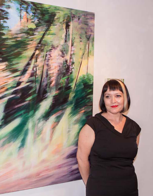 Image of artist and coach in front of large abstract landscape painting at gallery. Amanda van Gils